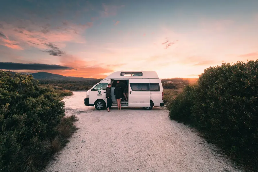 Ein Campervan bei Sonnenuntergang mit offener Schiebetür
