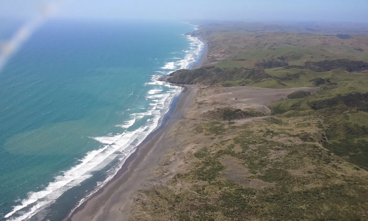 Küste mit schwarzem Sand bei Raglan